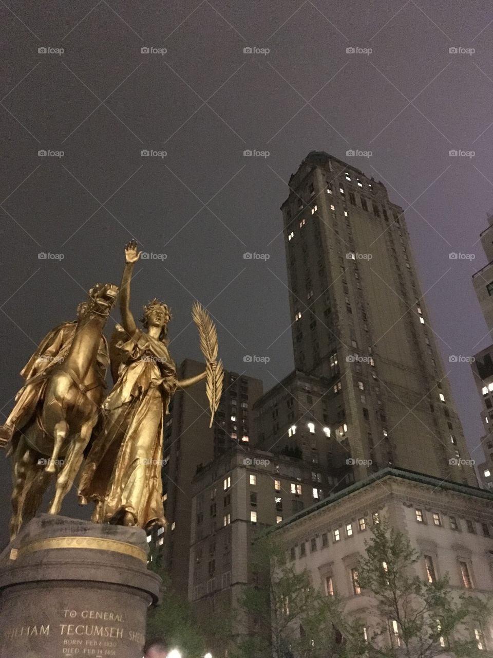 Golden statue and skyscrapers on a hazy night 