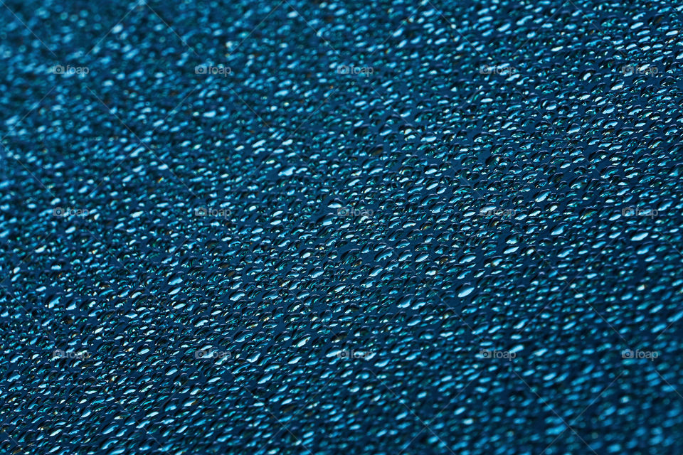 Water droplets texture on blue surface background. Selective focus, drops pattern backdrop