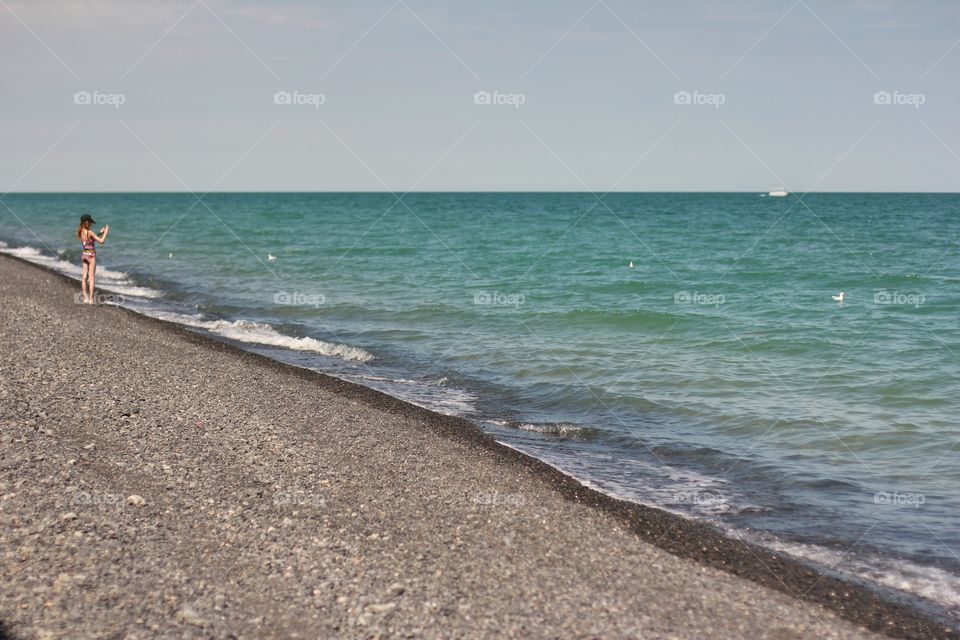 Girl takes pictures of seagulls on the beach