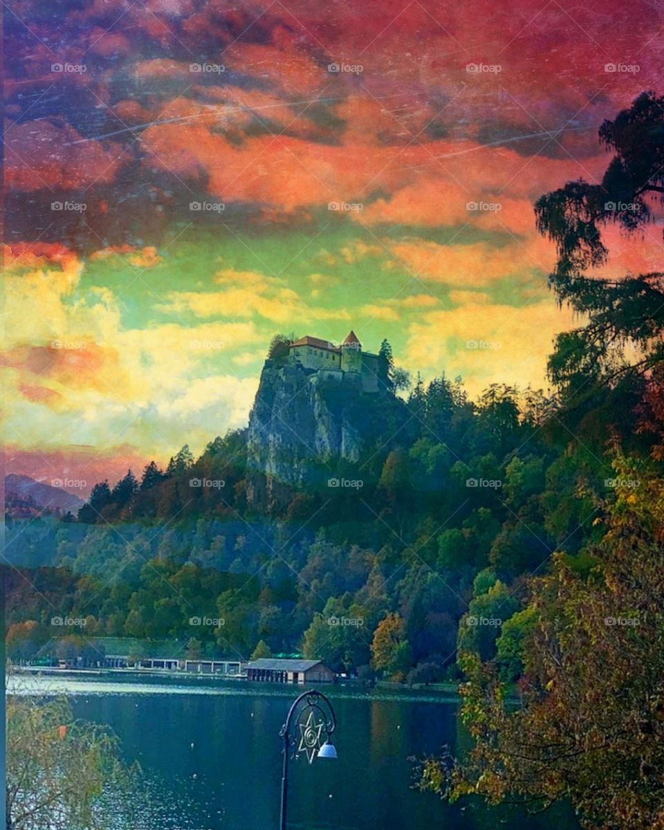 Village or city.  Spaces of nature.  Lake Bled (Bleysko).  Bled Castle stands on a steep green rock.  Slovenia.  Sunset, lake, mountain, castle