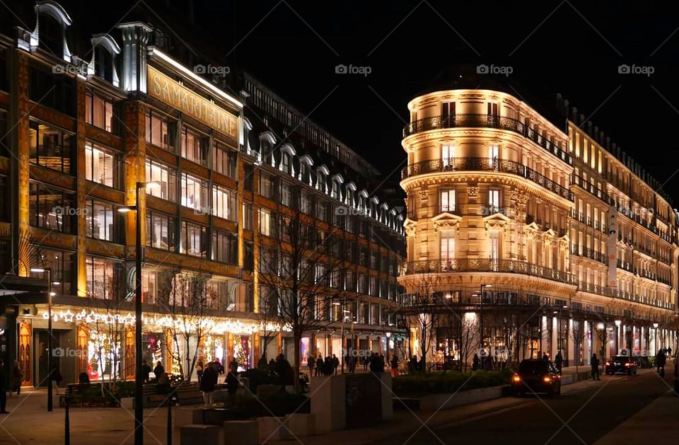 Illuminated windows of the Samaritaine Art Nouveau and Art Deco department stores in Paris under a dark sky