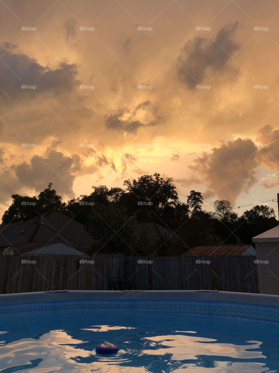 Beautiful golden and storm cloud sky reflected in the pool water making a beautiful photo. 