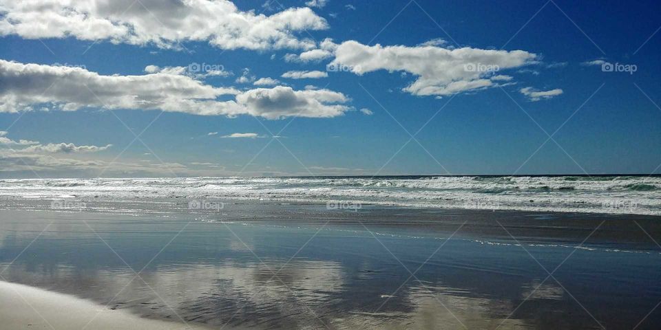 Glassy sea, puffy clouds, rolling surf