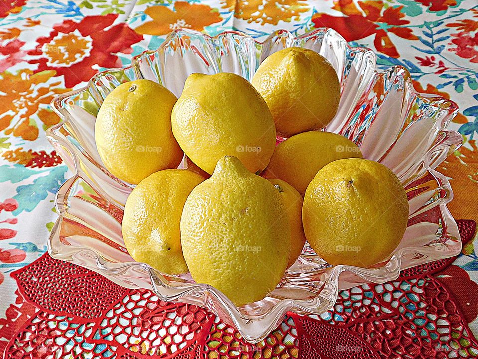 Fruit - Lemons displayed on a bowl on a decorative table cloth - Lemons are a popular fruit that is high in vitamin C and many powerful nutrients 