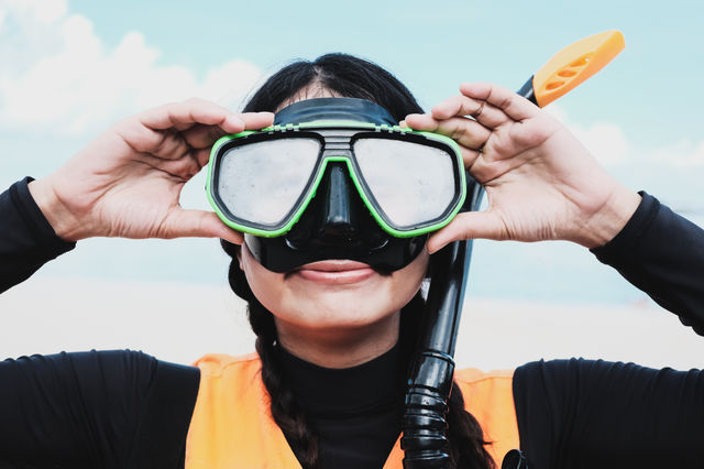 Close-up Asian woman wearing a black half- face snorkels