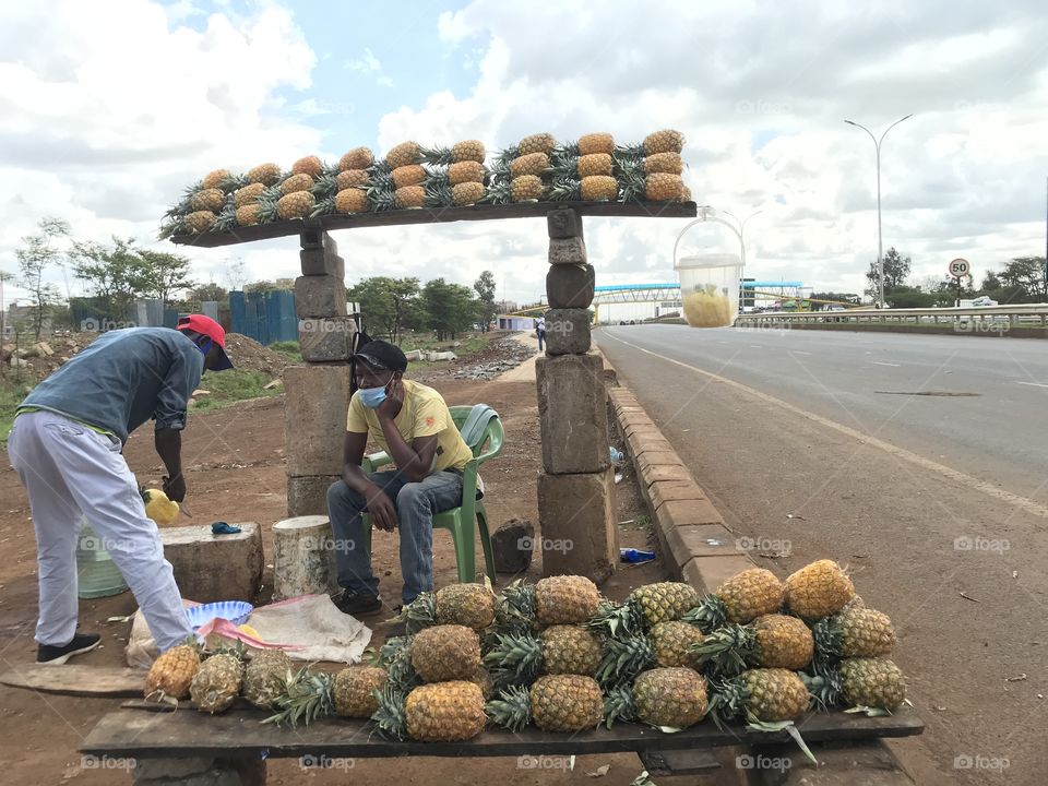 Pineapples ready for sale .This is a  busy superhighway and a lot of people and vehicles use this superhighway.Photo taken by me and my friends as we had a tour there.