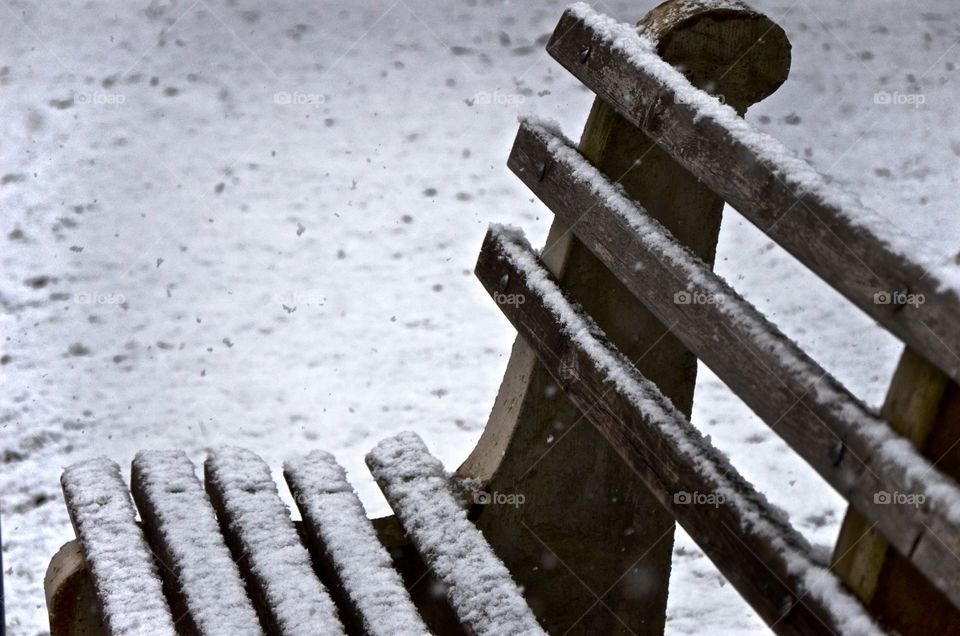 Falling snow. Snow starting to dust a bench on Penn State's campus.