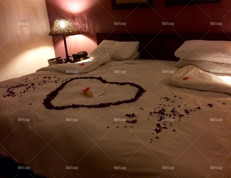 King size bed in Game lodge decorated for birthday celebrations in a romantic theme with low bedside lighting 