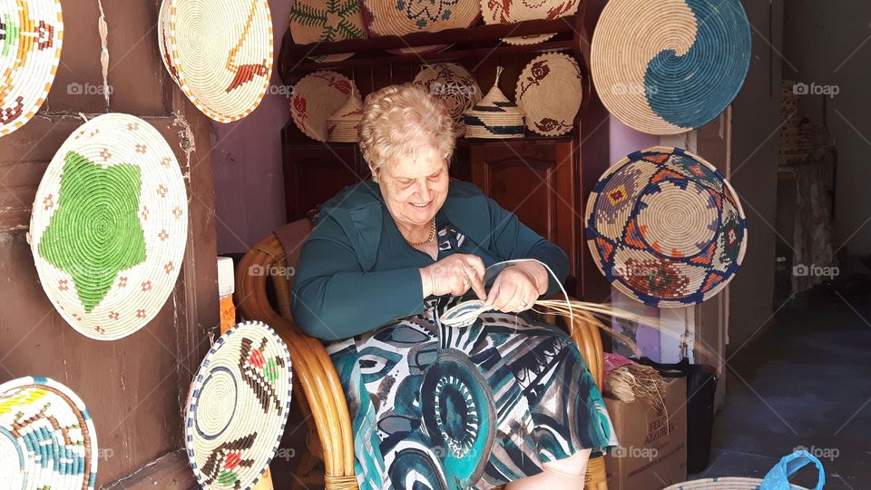 An elderly lady making baskets
