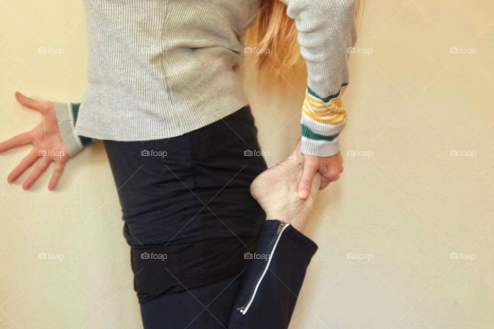 Woman doing stretching exercises on a wall
