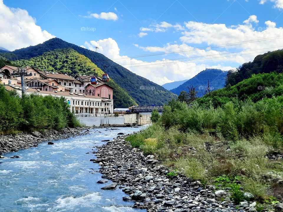 Wonderful bright sunny early autumn day in mountain town Rosa Khutor, Russia, with Mzymta river