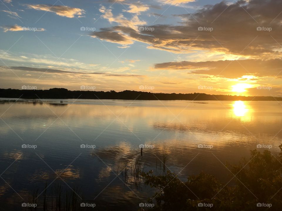 Sun setting on reflective lake