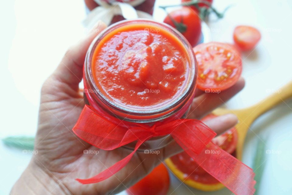 A person holding tomatoes sauce