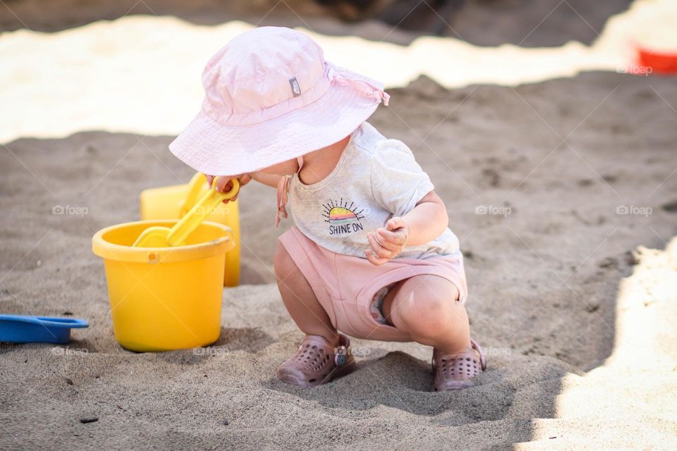 Cute toddler is playing in the sand