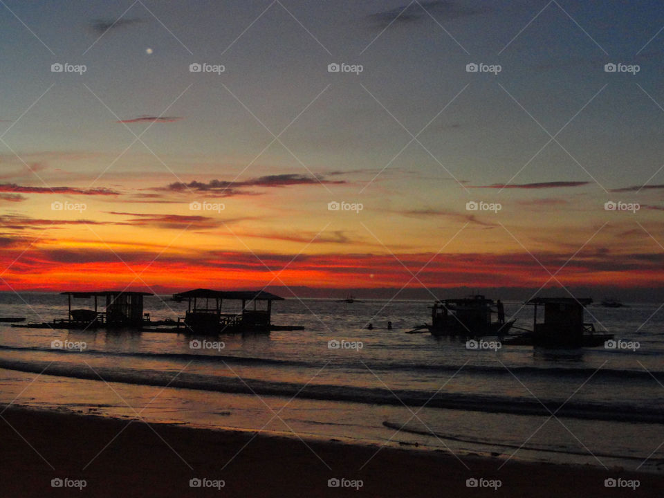 Scenic view of beach against sky at sunset 