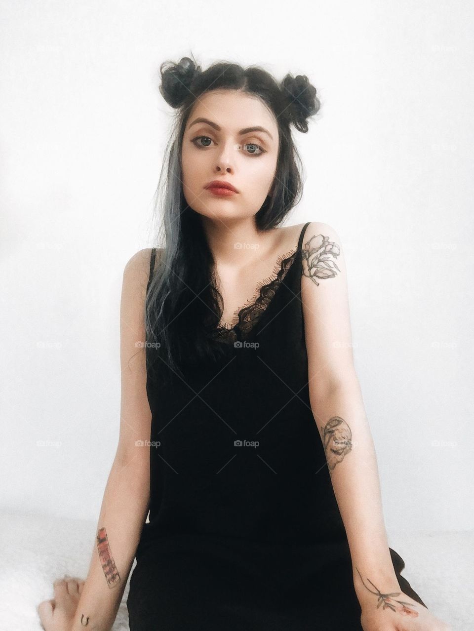 Portrait of a young woman with tattoos and black hair