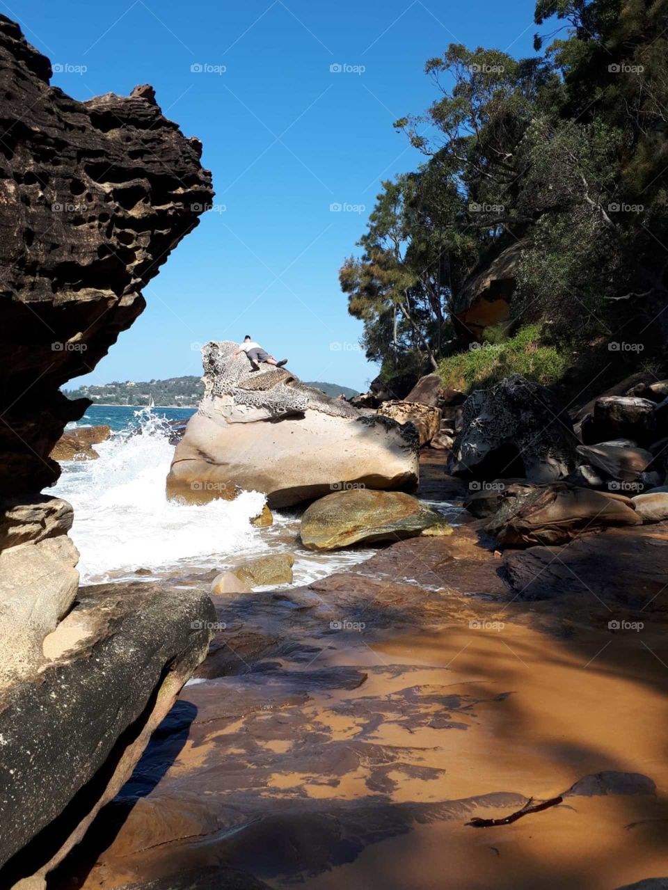 Man laying on the rock of curl curl beach Australia 