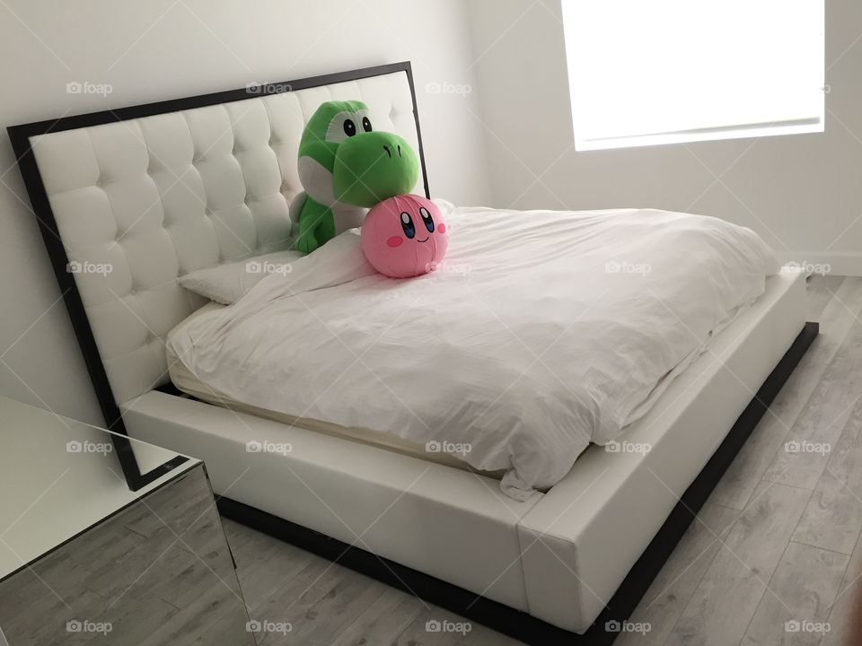 Yoshi and kirby on a modern bed
