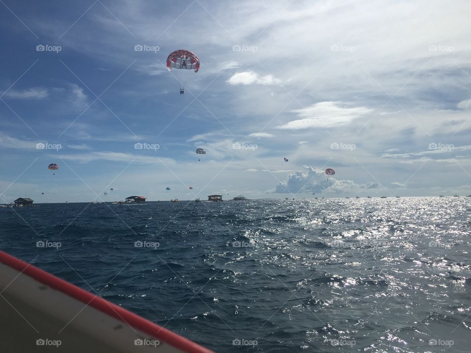 Boating in open water near a water park on the water. 