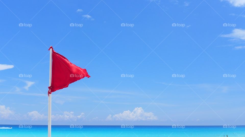Red flag warning dangerous water sign, on a caribbean summer sunny