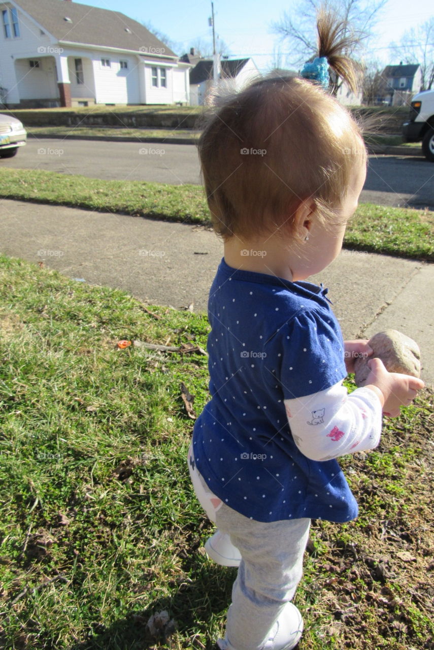 Baby playing with a stone.