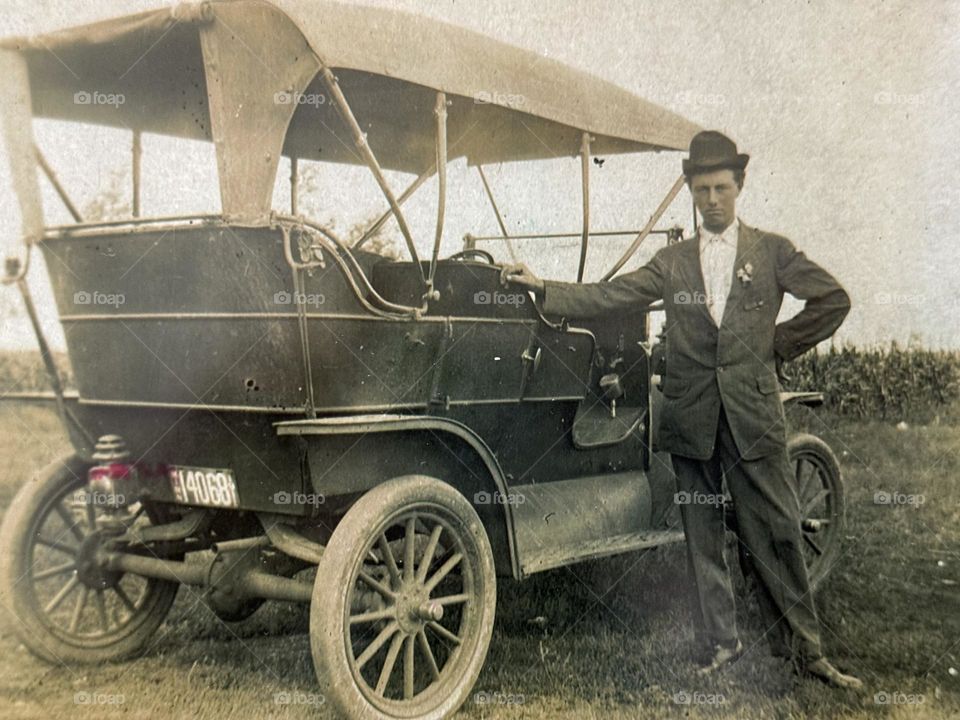 Proud man with bolo hat next to his car