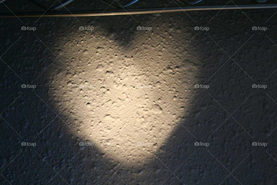 Heart shaped light reflection on a wall.
