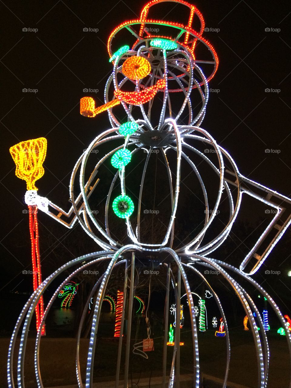 Tall snowman in lights at night