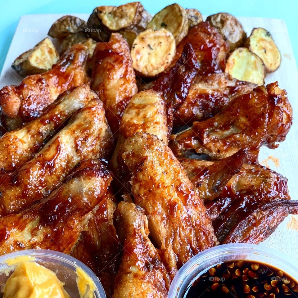 Barbecue chicken wings with nacho cheese sauce and mini potatoes 