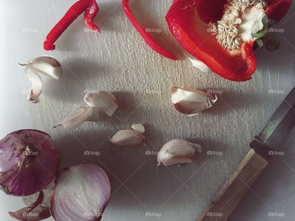 Home food preparation with garlic, onions, and capsicum. 