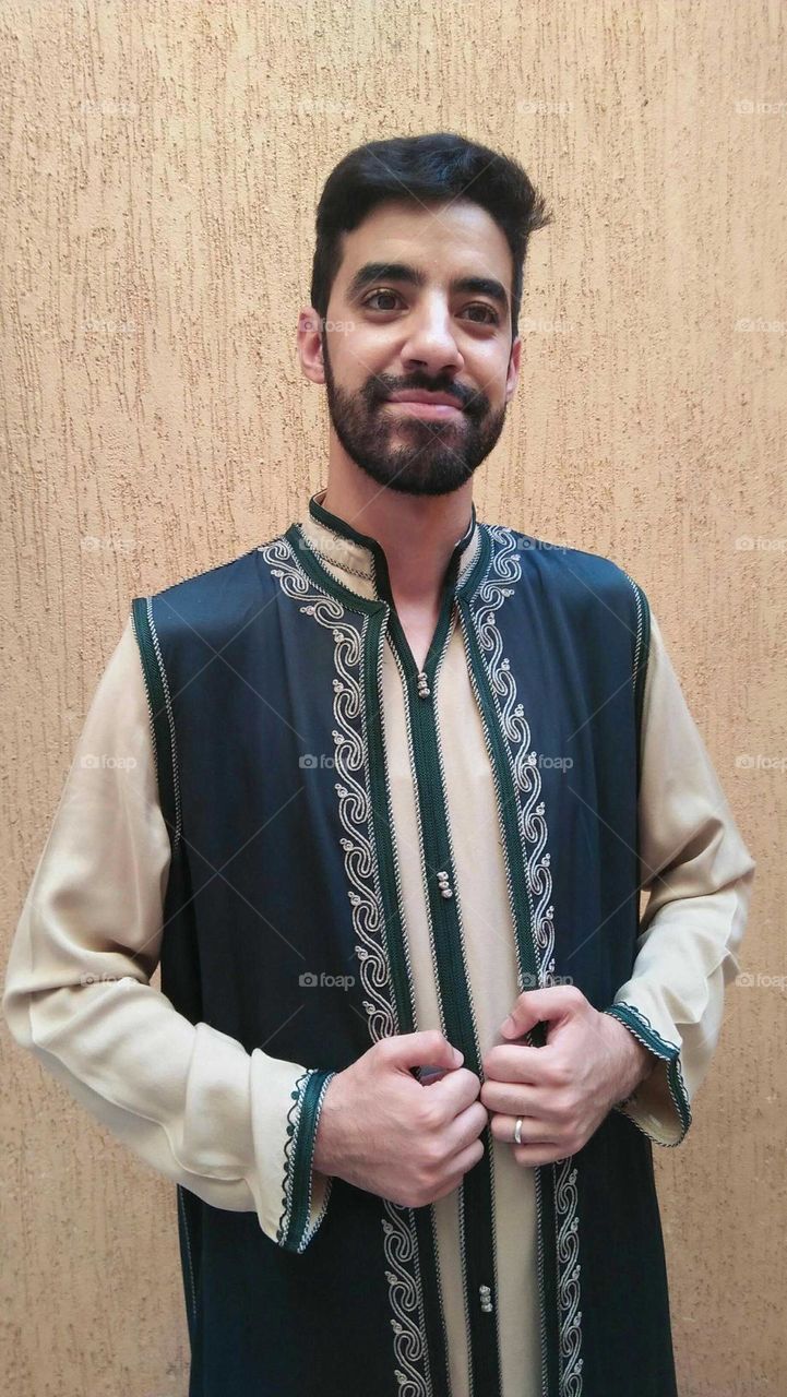 A handsome man wearing traditional moroccan clothes.