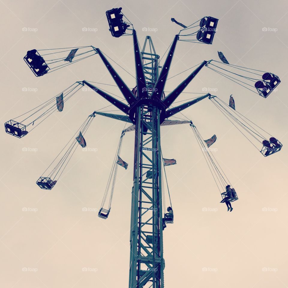 Fairground ride  at amusement park with plain background and sky 