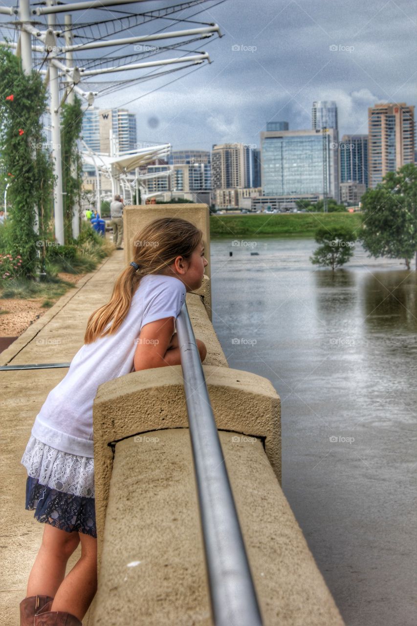 Penny for your thoughts. Girl looking at nature from a bridge