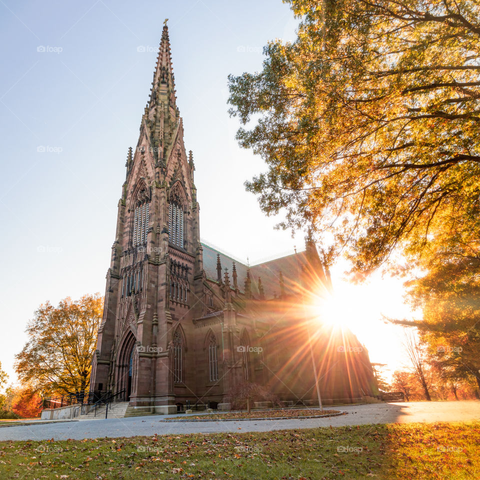 Huge golden sunburst as the sun sets behind a beautiful old cathedral. 