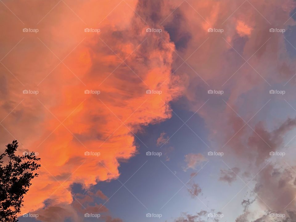 Sunset’s orange clouds contrast against a blue sky.