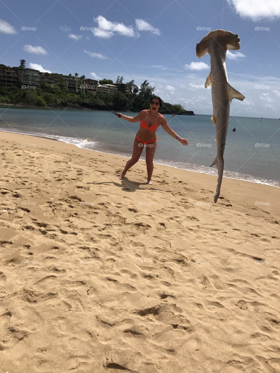 Scared woman on sandy beach near fish