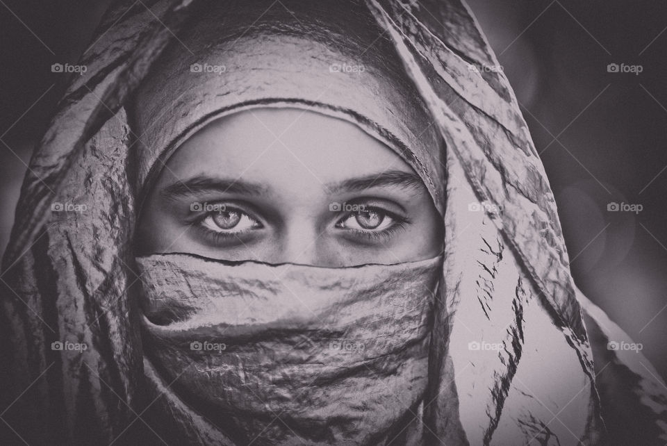 Girl with a Head Scarf Covering with Haunting Eyes Black and White