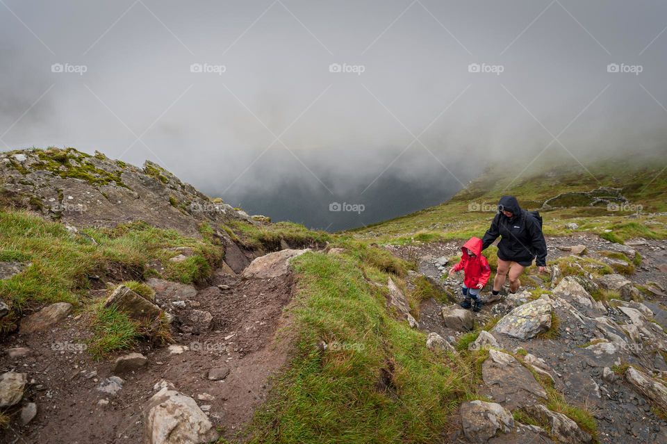 Mum with little boy on rocky mountain hike.