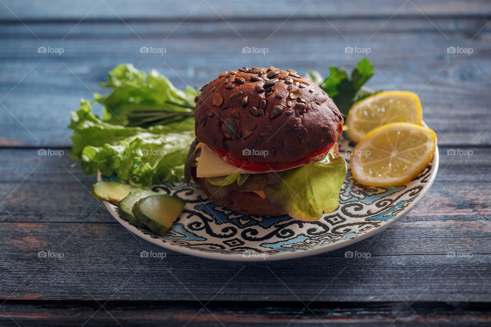 Dark burger with grain bread, cream cheese and avocado