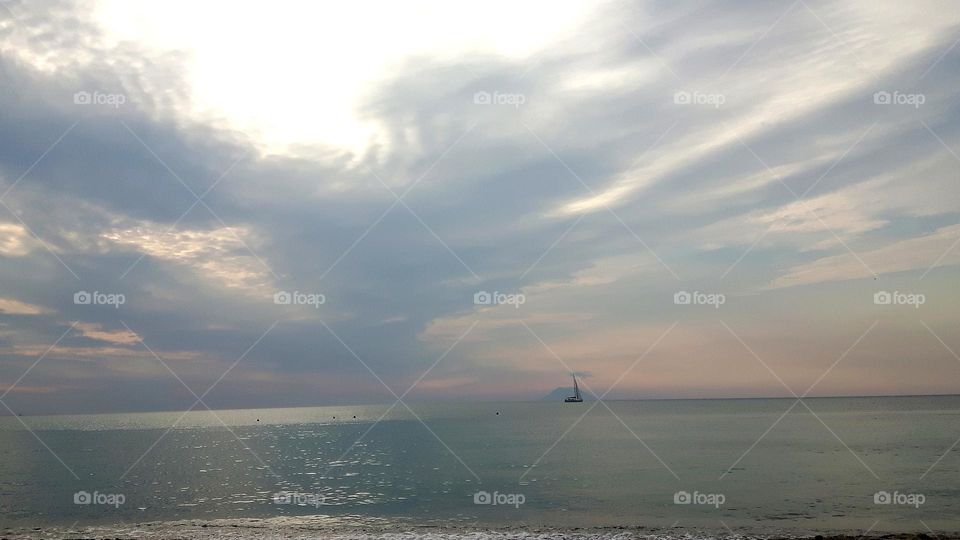 Sailboat at sunset with Stromboli in the background