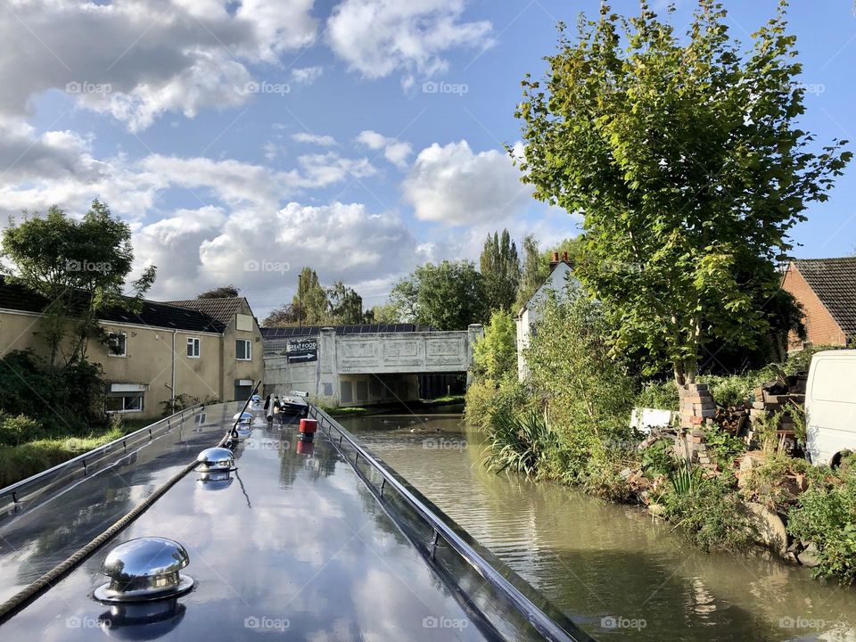 Late summer afternoon narrowboat cruise Oxford canal bridge cruising towards Hawkesbury Junction going past The Old Crown Pub cool clouds sky water reflection