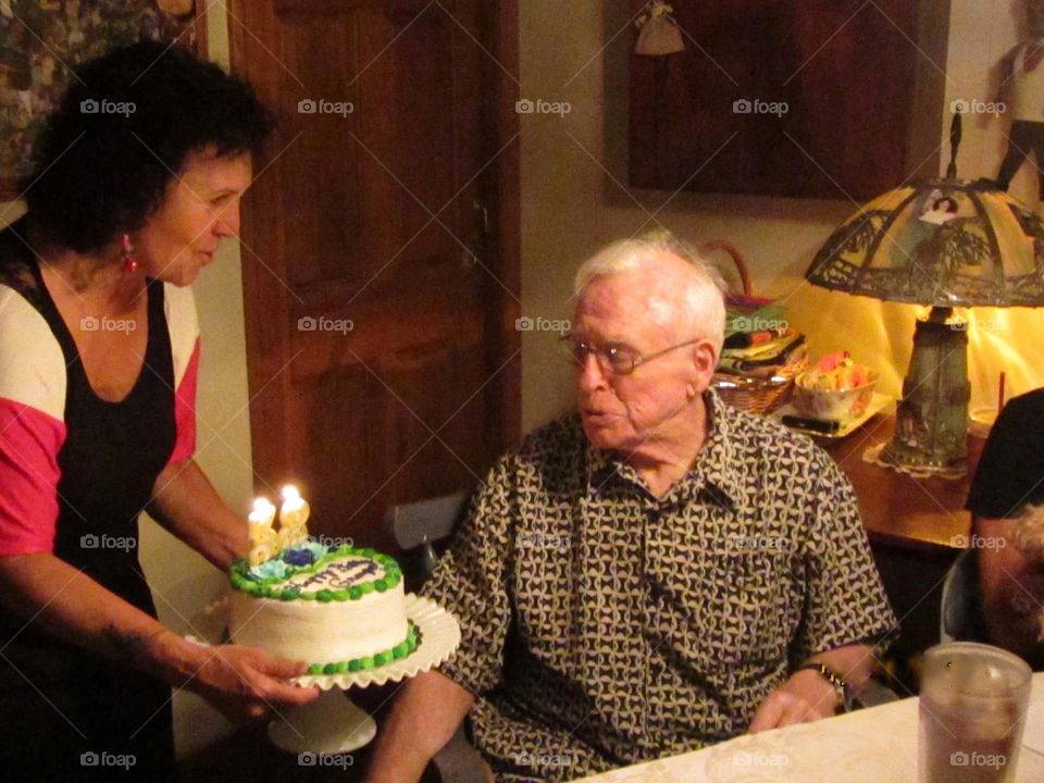 Birthday cake handed to older relative, number candles reversed as joke, 83 years old.