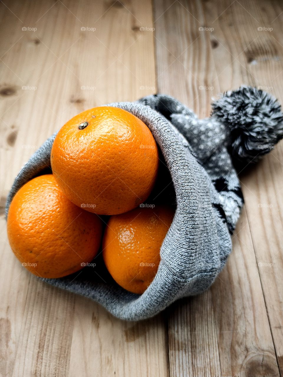 Oranges in a winter hat with bubo