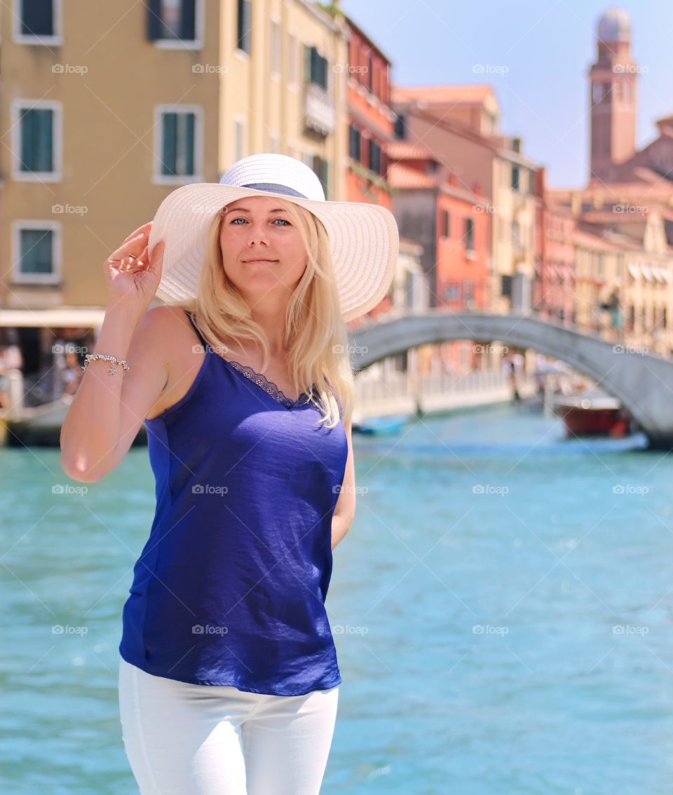 Yang blonde woman in hat in Venice 