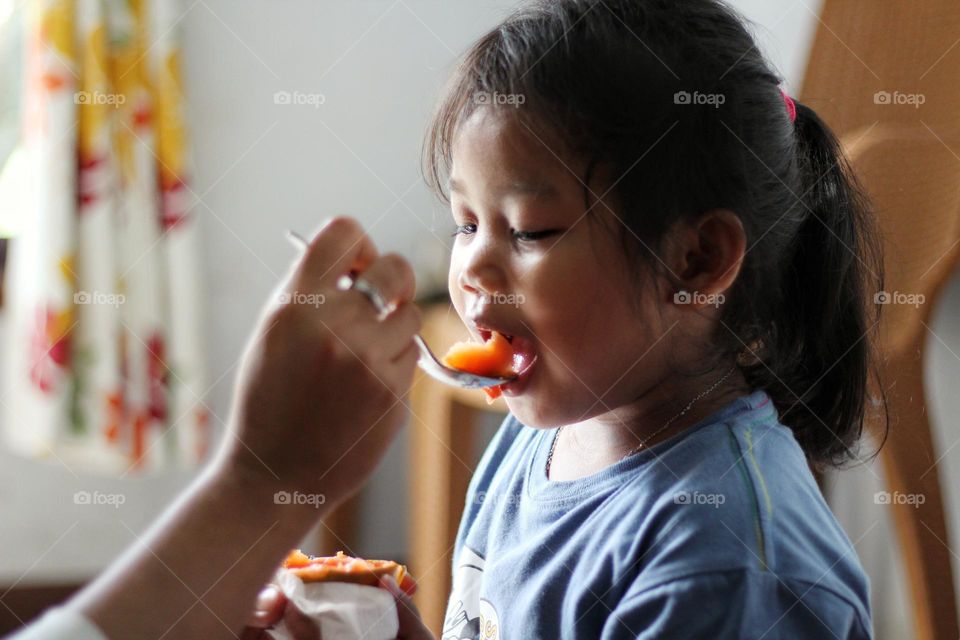 Portrait of a child being fed.