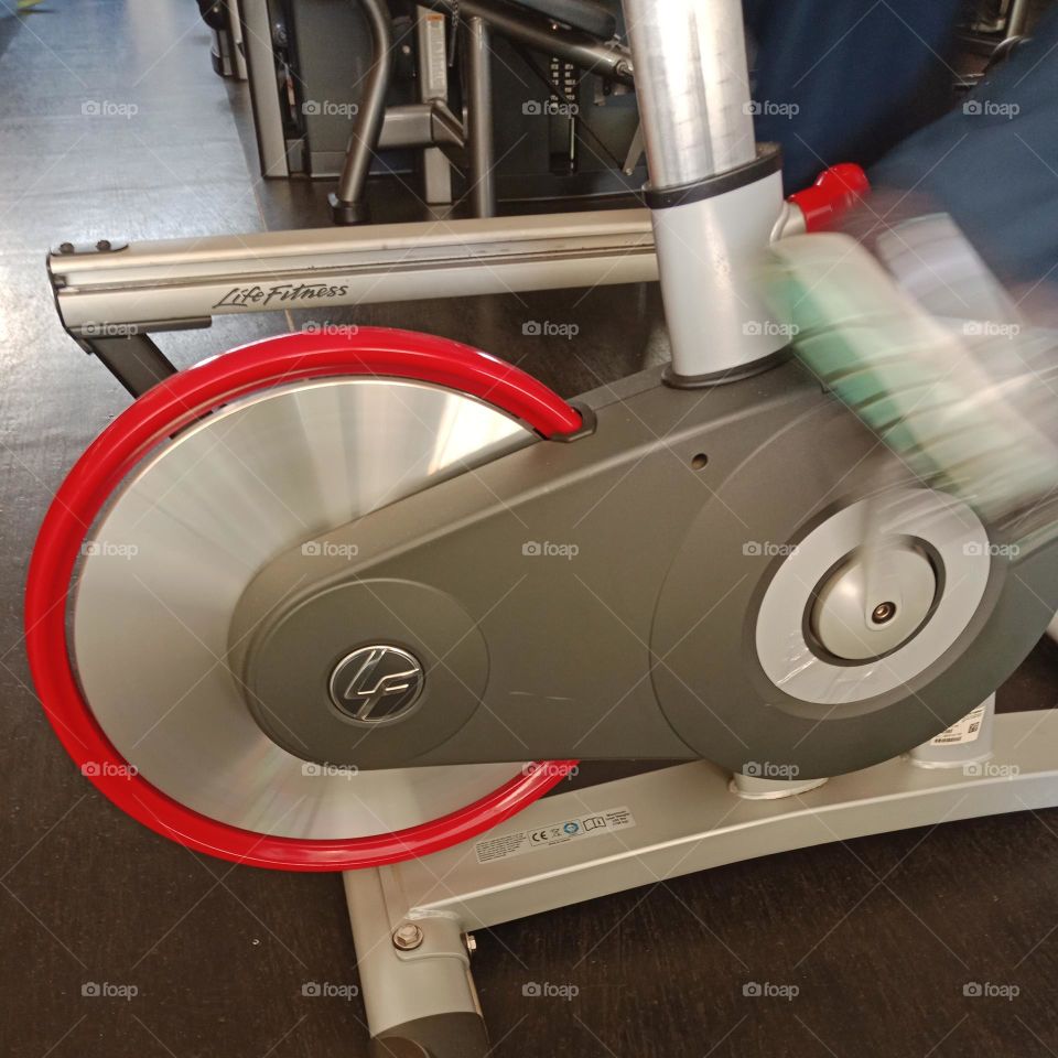 Moving a red metal wheel on a gym bike
