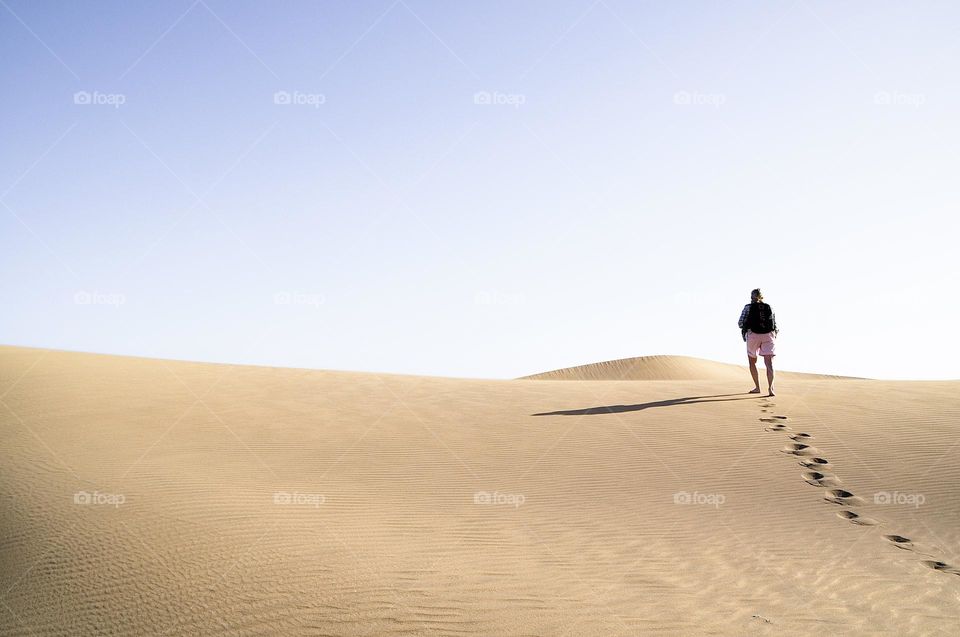 Minimal photo of a woman walking in desert