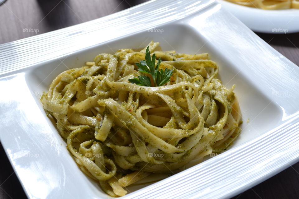Close-up of pesto pasta on white plate