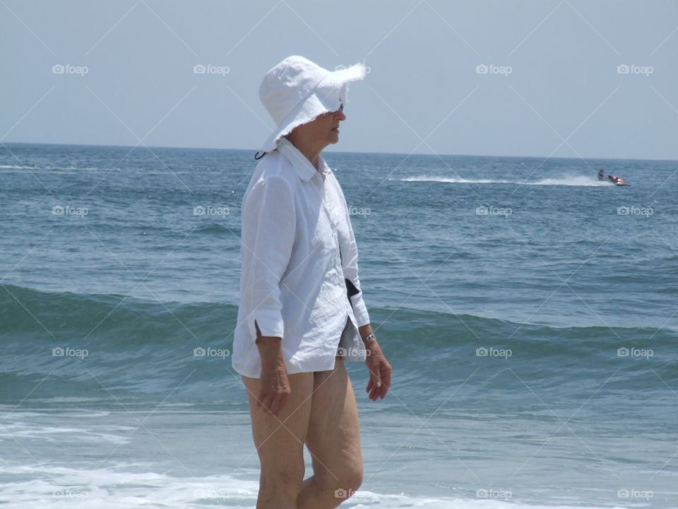 Elderly Woman walking on beach