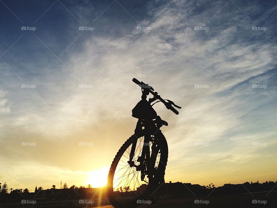 bycicle in front of sunset . bycicle silouhette in front of sunset 